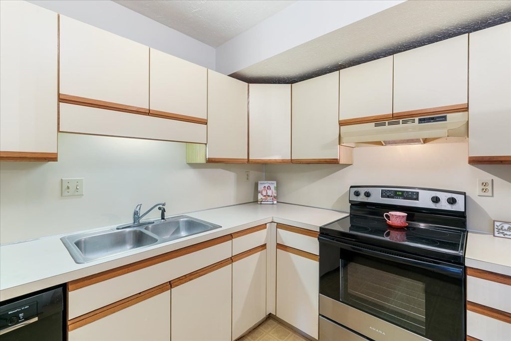 5 Tsienneto Road, Unit 187 Derry, NH 03038 - Photo 4 of 27 a kitchen with stainless steel appliances a stove and cabinets