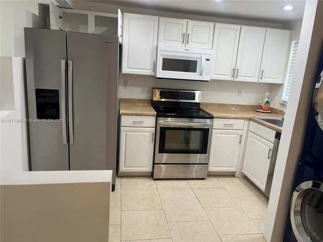 a kitchen with stainless steel appliances a stove a microwave and a refrigerator