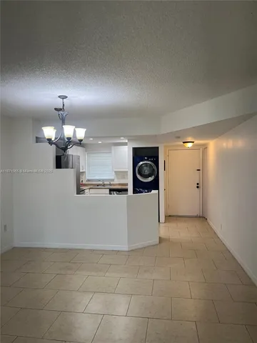 a view of a kitchen with a sink and a refrigerator