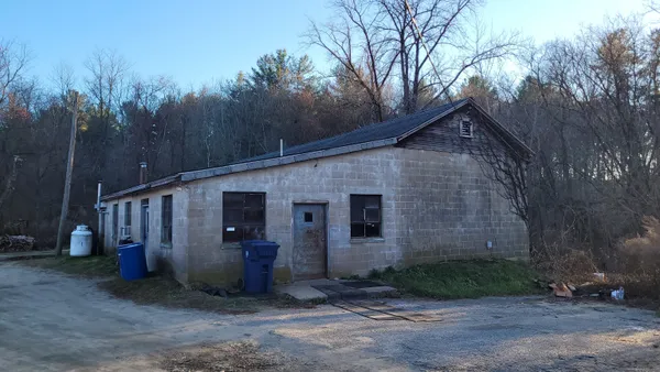 a view of a house with backyard and trees