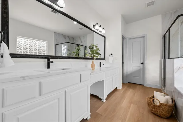 a bathroom with double vanity sink and mirrors