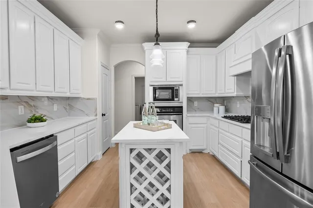 a kitchen with stainless steel appliances granite countertop a sink a stove a refrigerator and cabinets