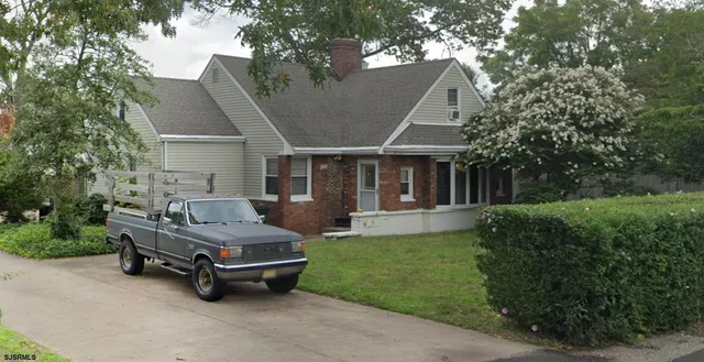 a car parked in front of a house with a yard