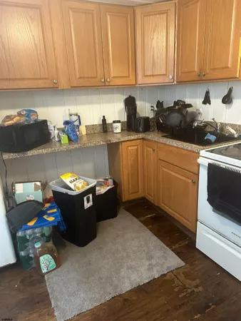 a kitchen with granite countertop a sink dishwasher stove and cabinets