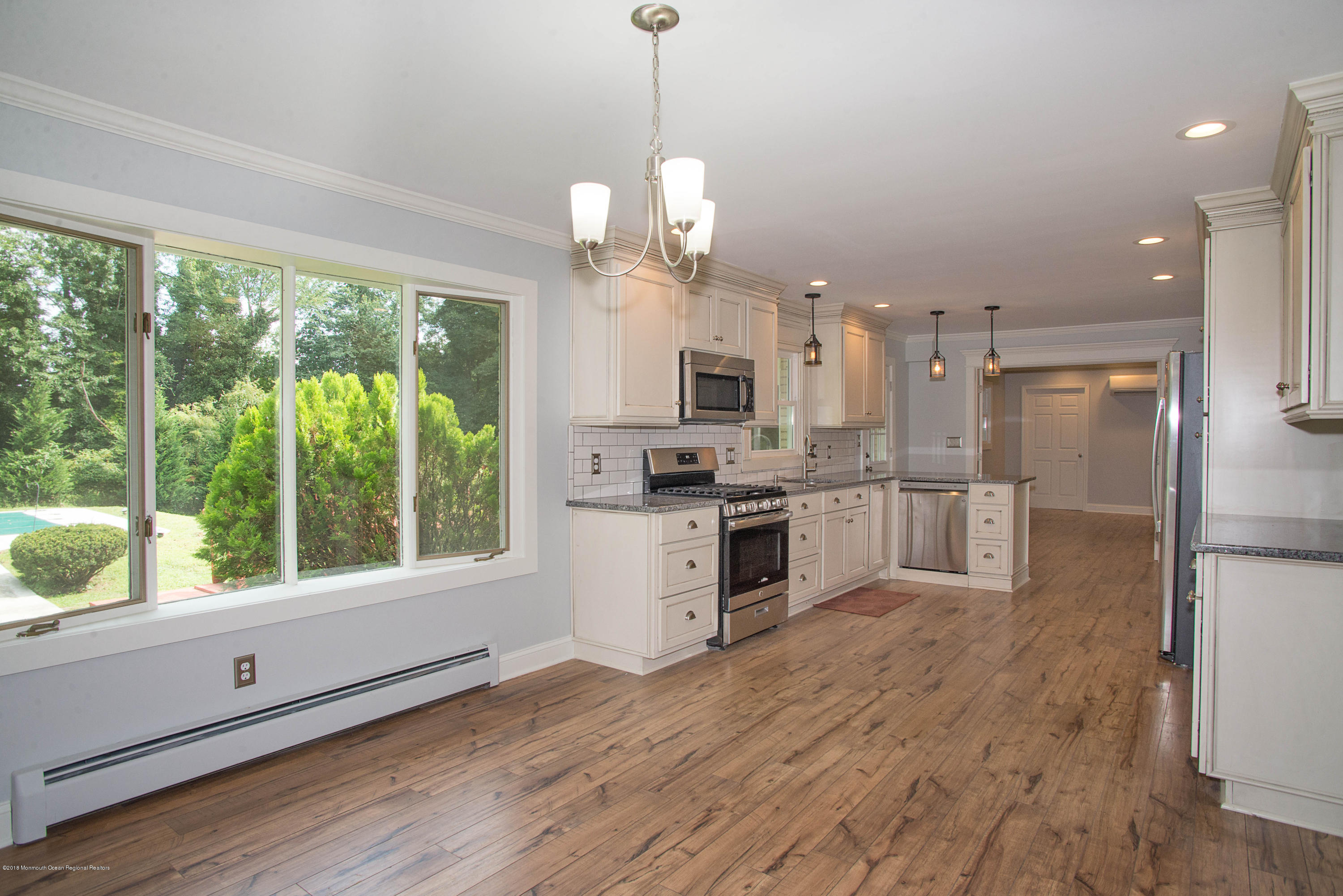 435 Burlington Road Freehold, NJ 07728 - Photo 6 of 24 a open kitchen with stainless steel appliances granite countertop a stove a sink dishwasher a refrigerator and a wooden floor