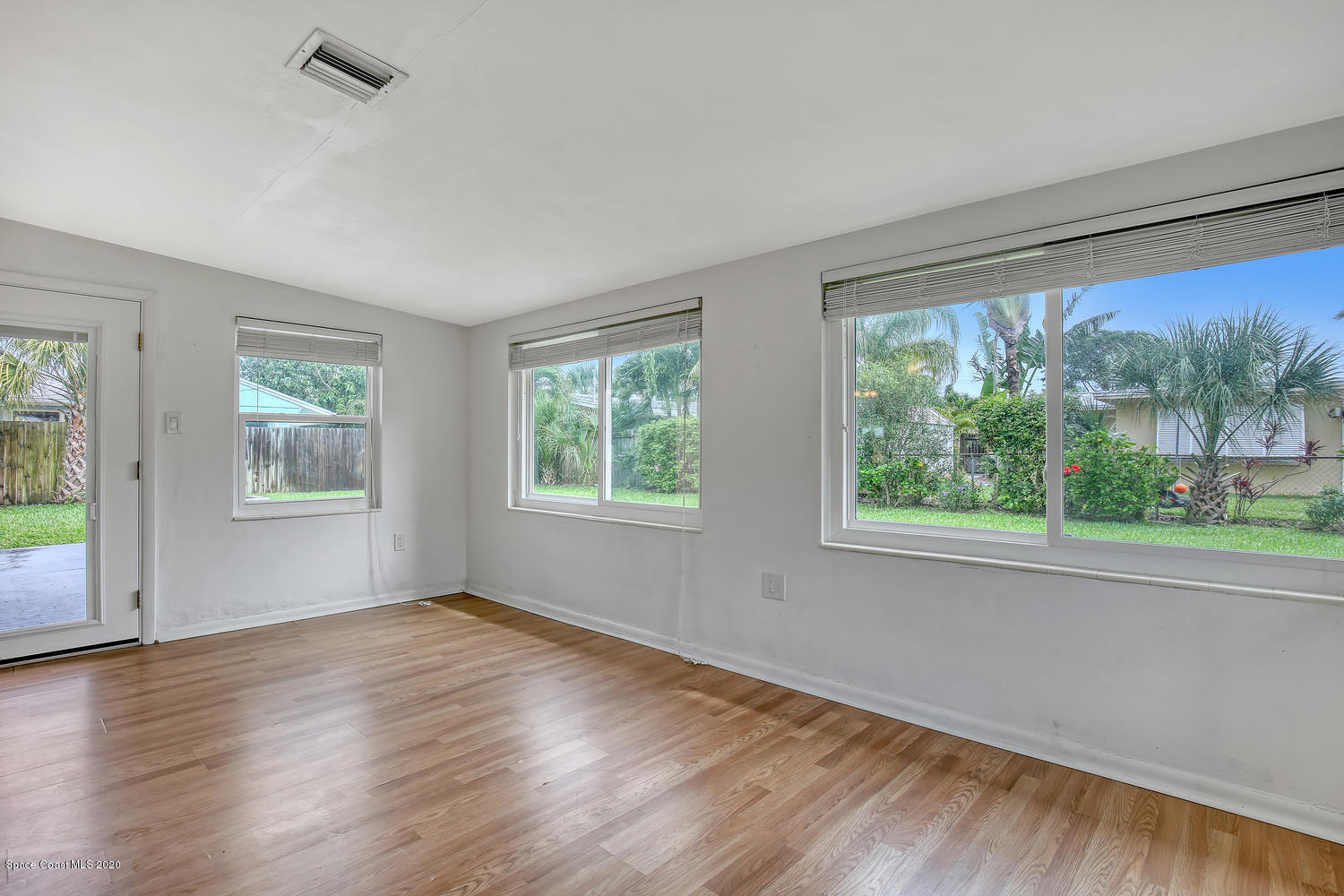 693 Bermuda Road Cocoa Beach, FL 32931 - Photo 22 of 33 a view of an empty room with wooden floor and a window