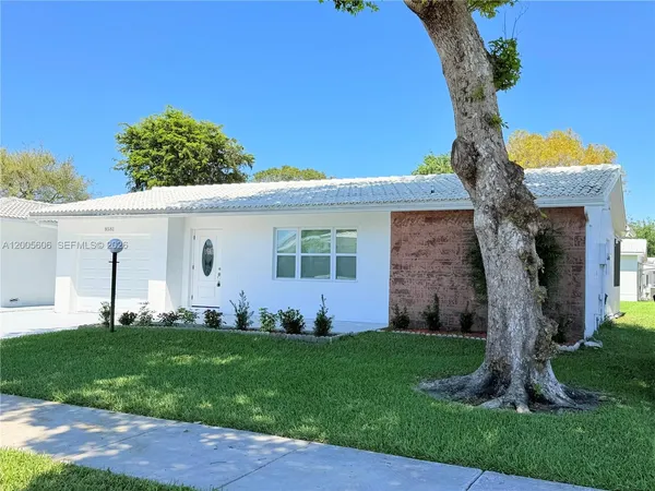 a front view of a house with a garden and yard