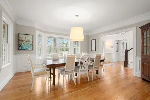 a view of a a dining room with furniture window and wooden floor