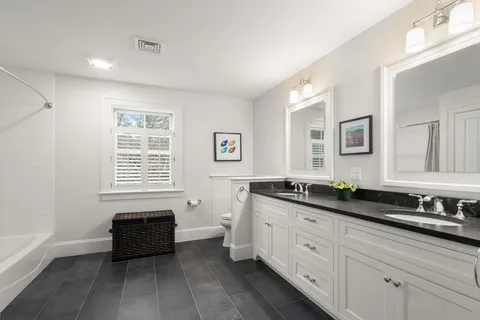 a spacious bathroom with double vanity and a mirror