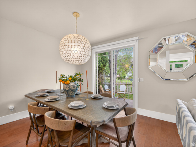 557 Craftsman Way Midway, UT 84049 - Photo 16 of 59 Dining area featuring wood-finish flooring, a contemporary spherical pendant light fixture, and a sliding glass door to the outdoor space