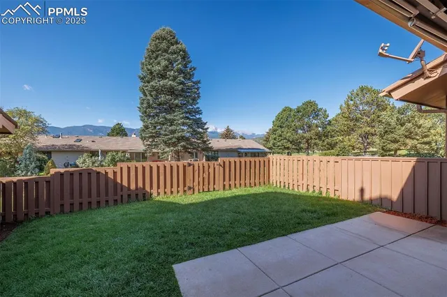 a view of a yard with wooden fence