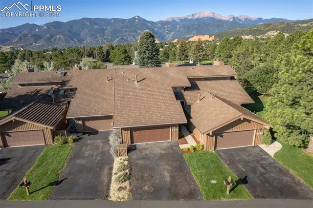 an aerial view of a house with a yard and mountain view
