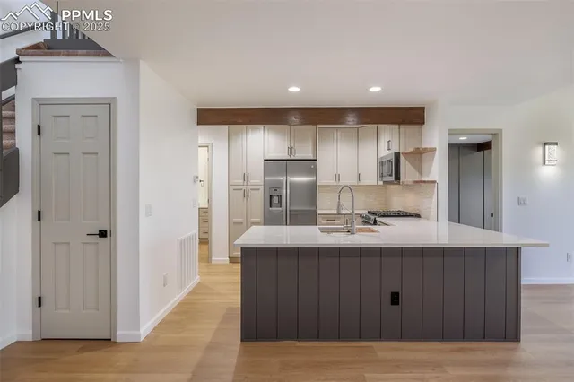a kitchen with kitchen island a sink and refrigerator