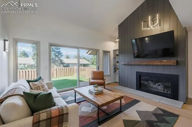 a living room with furniture a flat screen tv and a fireplace