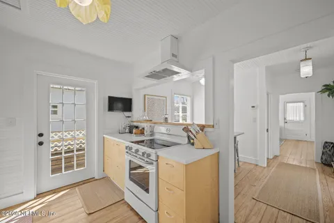 a kitchen with stainless steel appliances granite countertop a refrigerator a sink dishwasher and white countertops with wooden floor