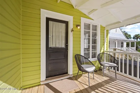 a living room with furniture a large window and wooden floor