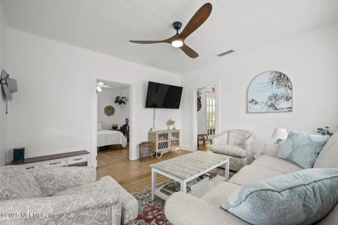a living room with furniture a flat screen tv and a window