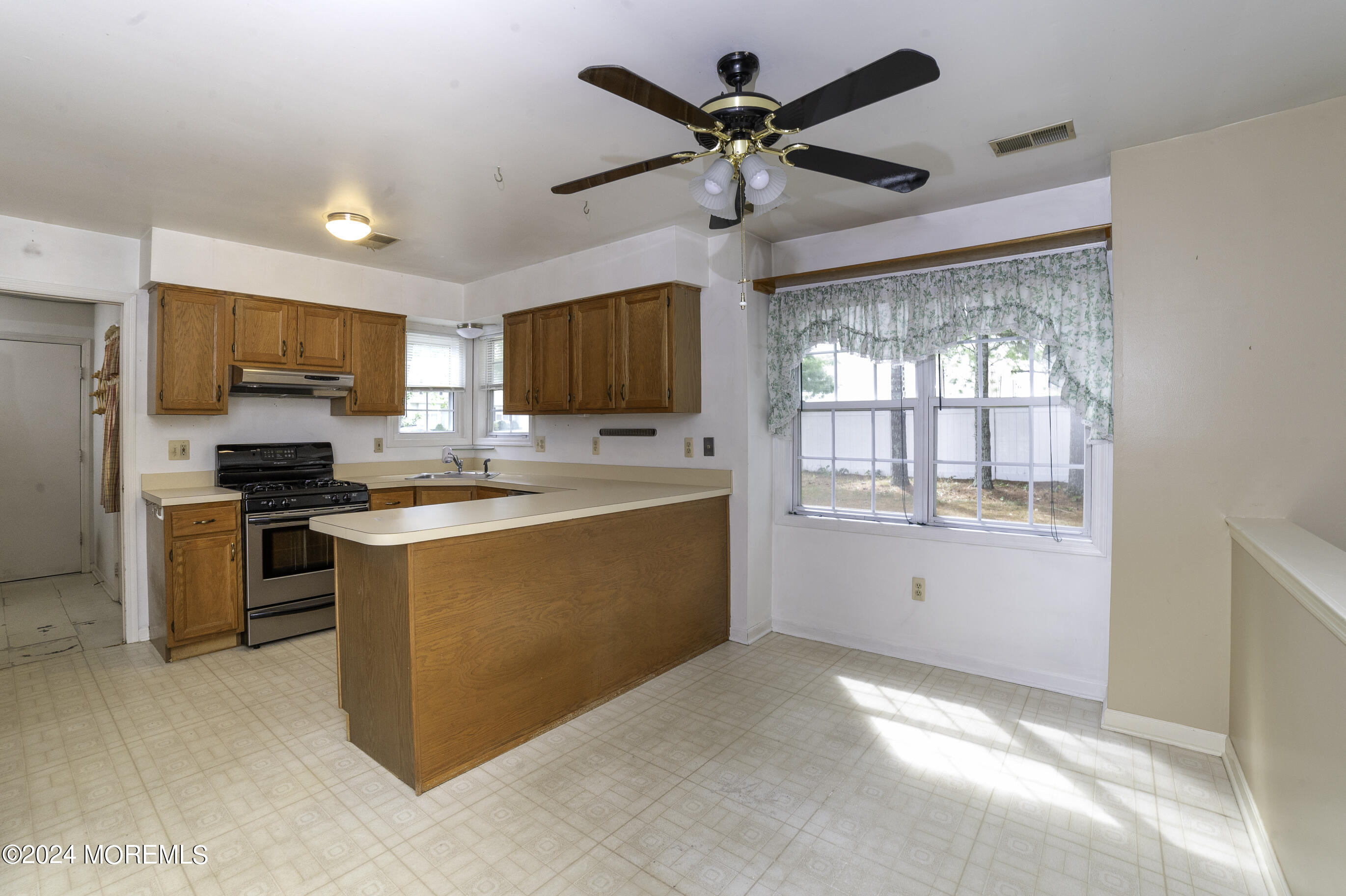 179 Wells Mill Road Waretown, NJ 08758 - Photo 7 of 28 a kitchen with stainless steel appliances kitchen island granite countertop a refrigerator a stove a sink a oven with a dining table and chairs