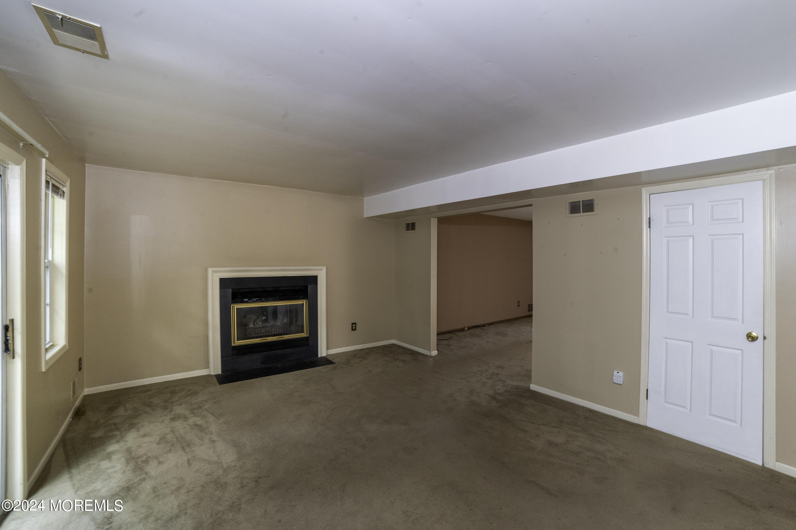 179 Wells Mill Road Waretown, NJ 08758 - Photo 10 of 28 a view of an empty room with a fireplace and a window
