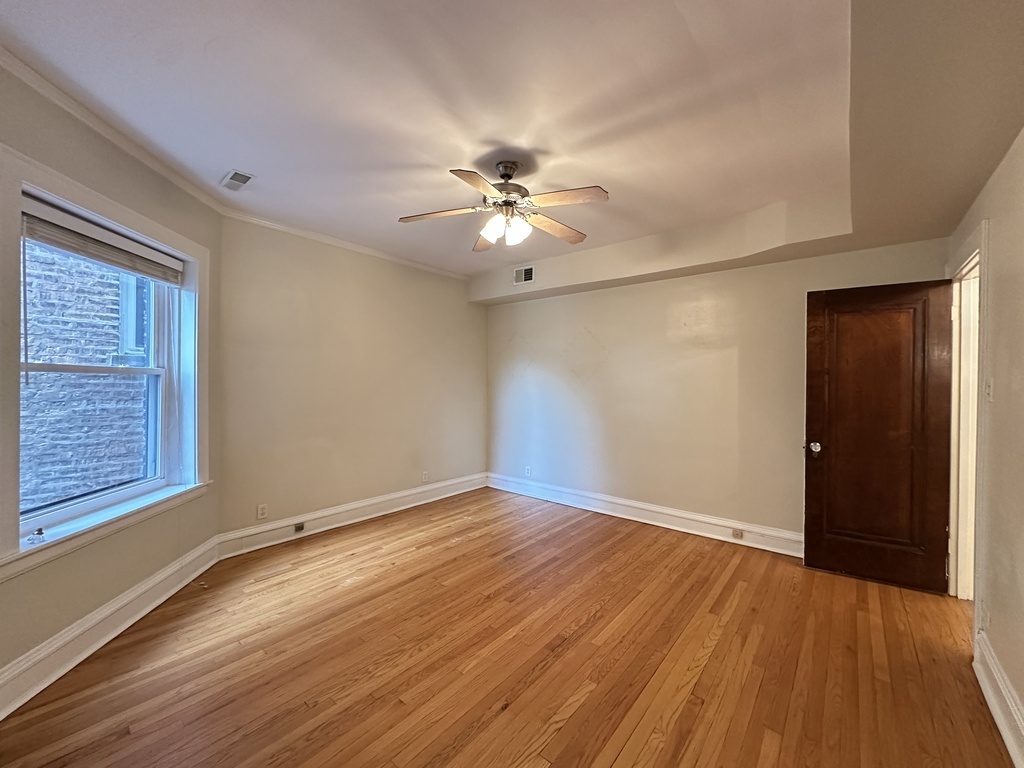 2619 West Greenleaf Avenue, Unit 2 Chicago, IL 60645 - Photo 16 of 22 a view of an empty room with window and wooden floor