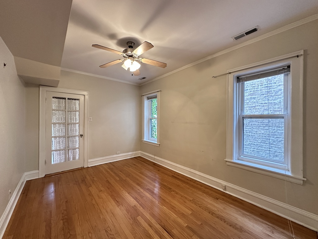 2619 West Greenleaf Avenue, Unit 2 Chicago, IL 60645 - Photo 17 of 22 a view of an empty room with a window and wooden floor