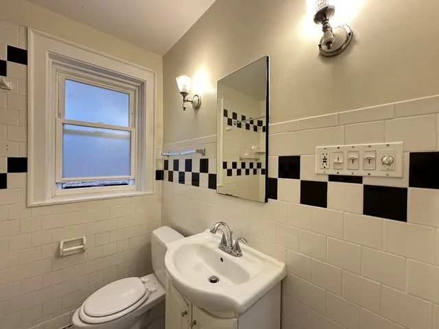 a bathroom with a toilet sink and mirror