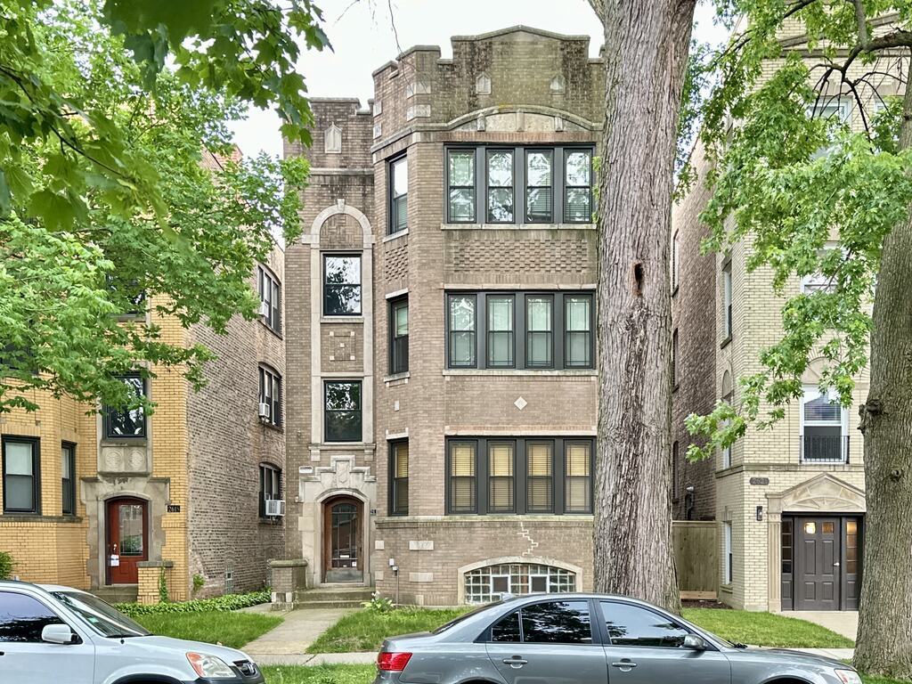 2619 West Greenleaf Avenue, Unit 2 Chicago, IL 60645 - Photo 2 of 22 a front view of a residential apartment building with a yard