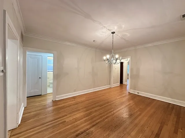 a view of a room with wooden floor and chandelier