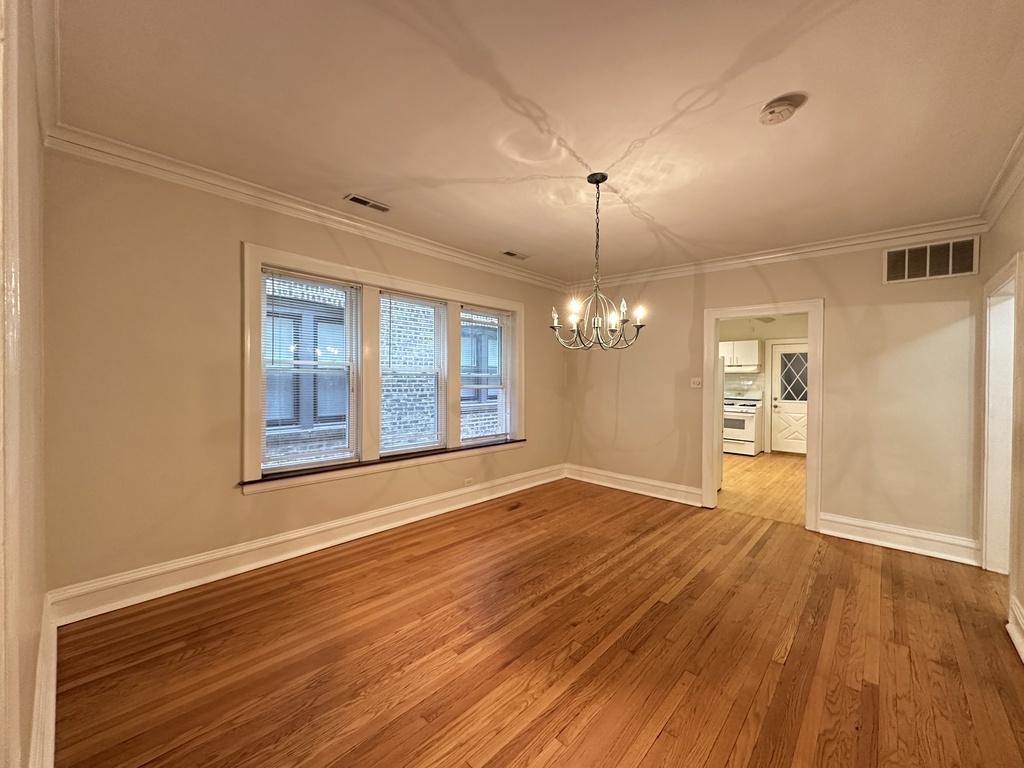 2619 West Greenleaf Avenue, Unit 2 Chicago, IL 60645 - Photo 8 of 22 a view of an empty room with wooden floor and a window