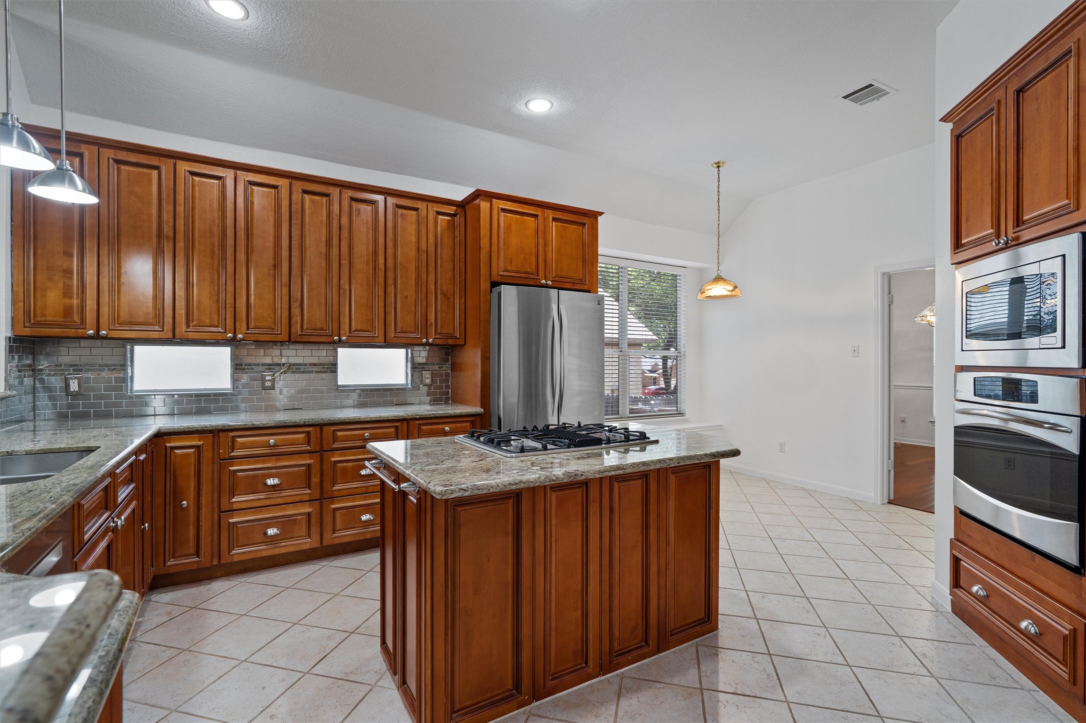 2328 Rodeo Drive Austin, TX 78727 - Photo 15 of 40 a kitchen with stainless steel appliances granite countertop a stove a sink dishwasher and a refrigerator with wooden cabinets
