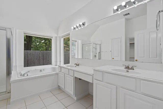 a bathroom with a sink tub shower and a mirror