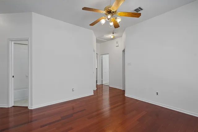 a view of an empty room with wooden floor
