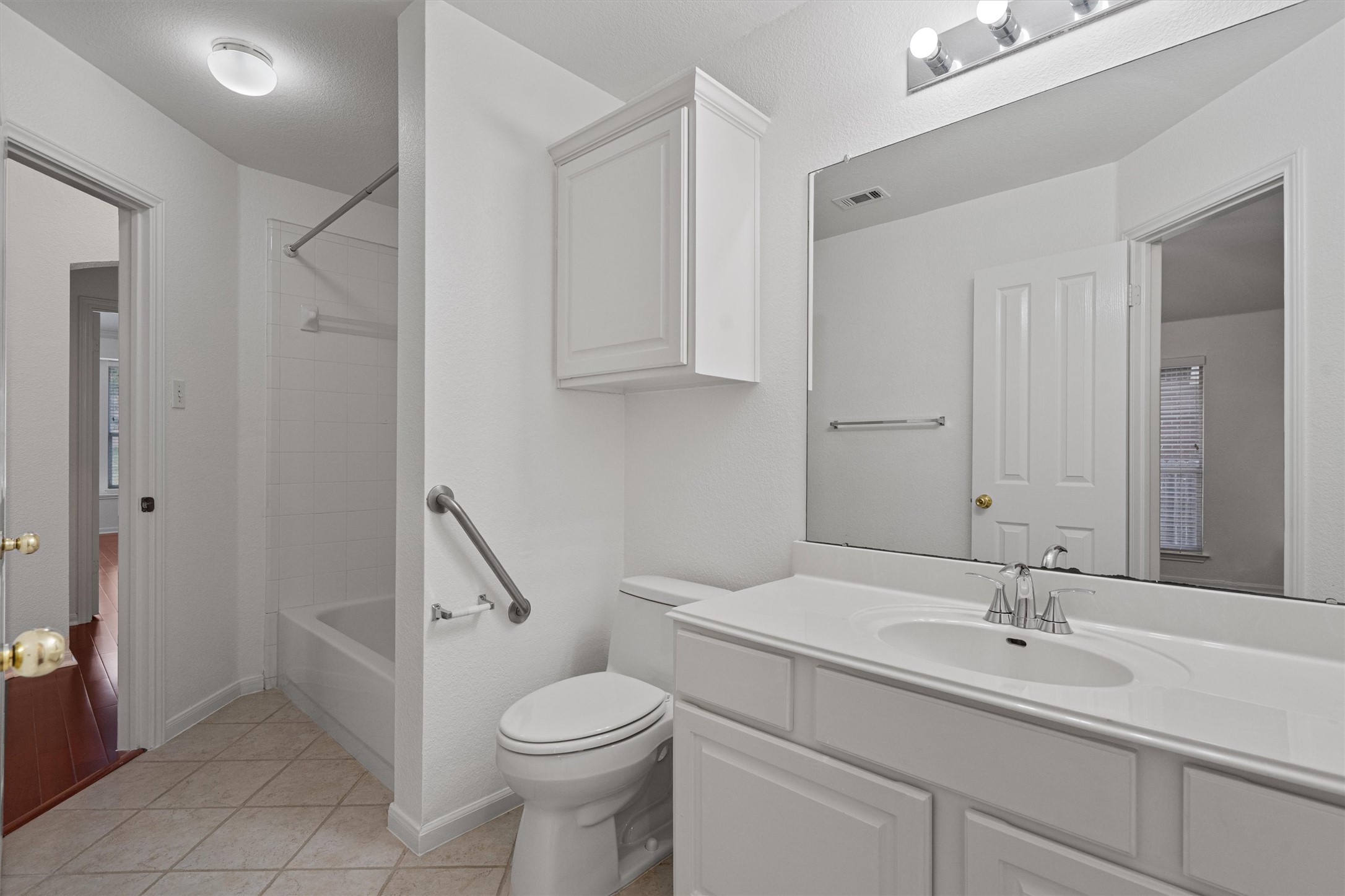 2328 Rodeo Drive Austin, TX 78727 - Photo 30 of 40 a bathroom with a sink a toilet and a large mirror