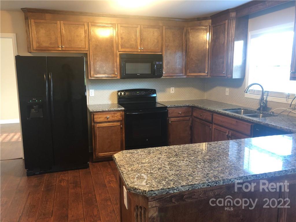 1401 Hickory Grove Road Gastonia, NC 28056 - Photo 4 of 12 a kitchen with a sink a refrigerator and cabinets