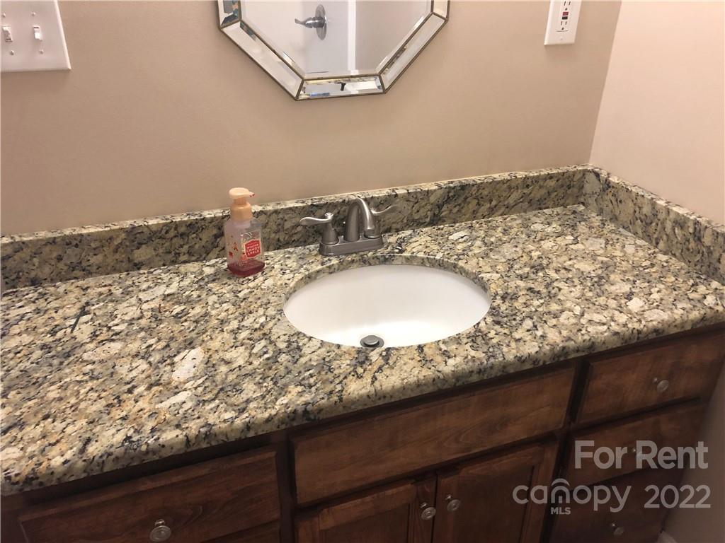 1401 Hickory Grove Road Gastonia, NC 28056 - Photo 7 of 12 a bathroom with a granite countertop sink and a mirror