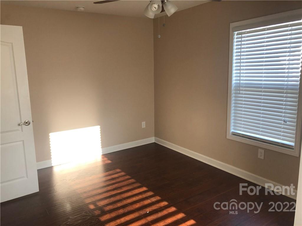 1401 Hickory Grove Road Gastonia, NC 28056 - Photo 10 of 12 a view of an empty room with wooden floor and a window