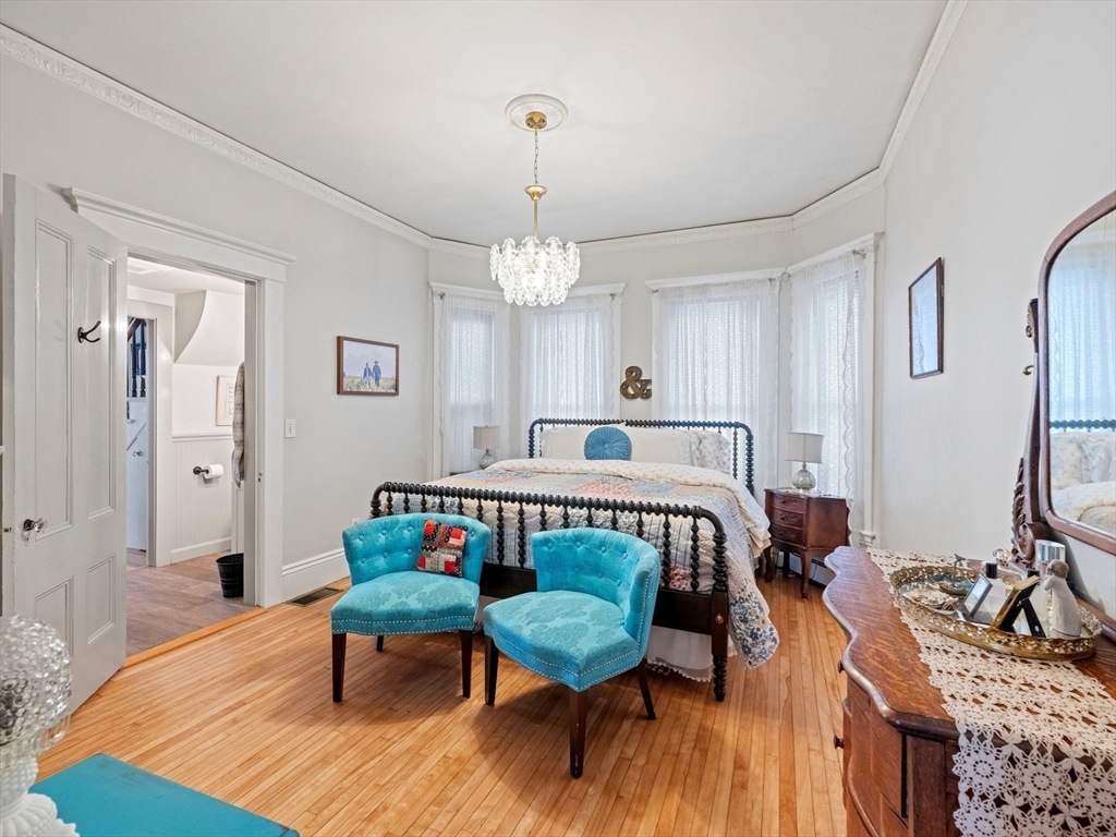 5 Holten Street Danvers, MA 01923 - Photo 18 of 42 a bedroom with a bed a chandelier and mirror