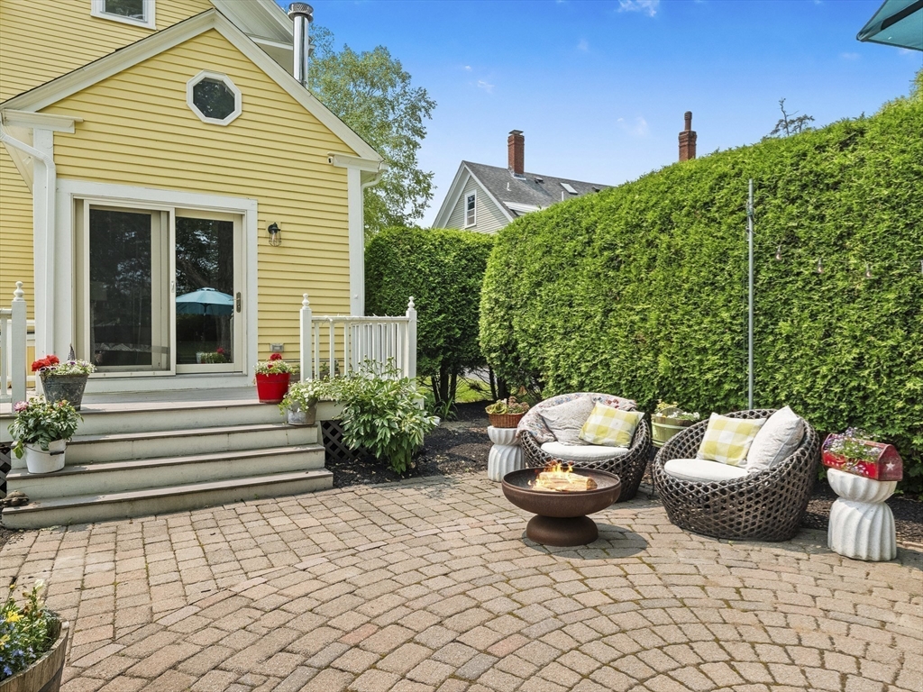 5 Holten Street Danvers, MA 01923 - Photo 38 of 42 a view of a patio with chair and tables back yard of the house