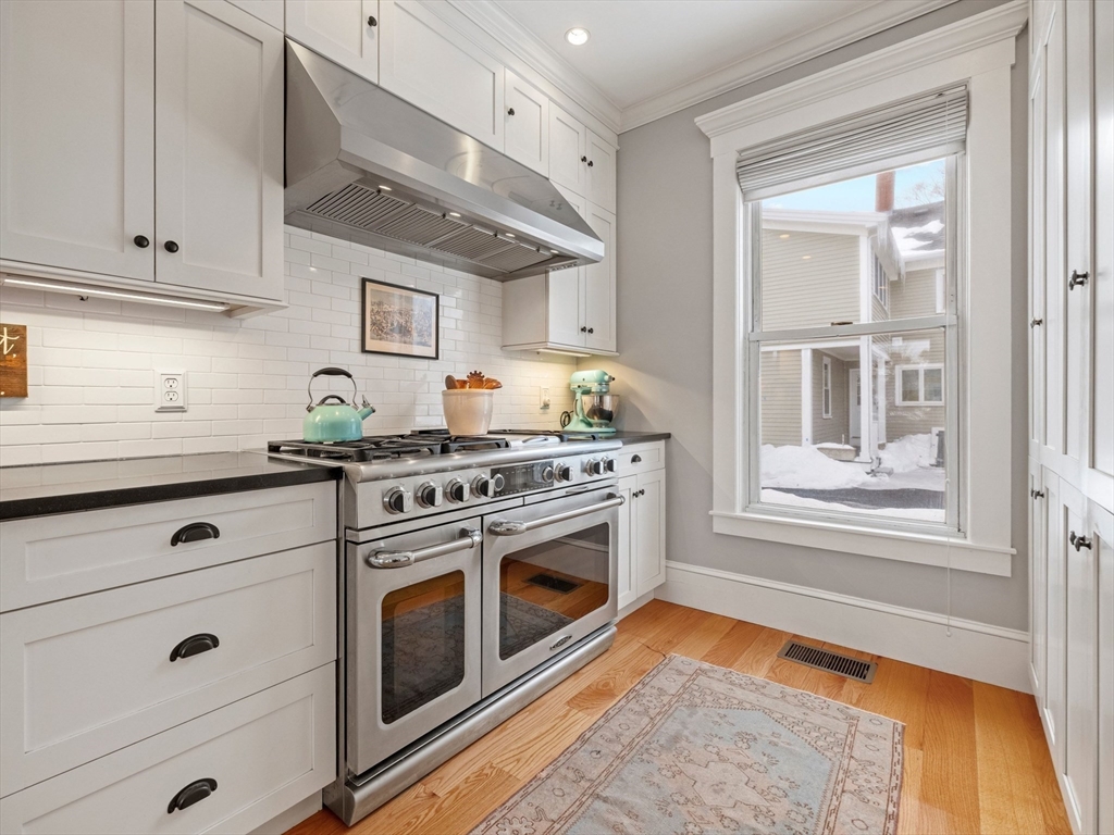 5 Holten Street Danvers, MA 01923 - Photo 6 of 42 a kitchen with stainless steel appliances white cabinets and a wooden floors