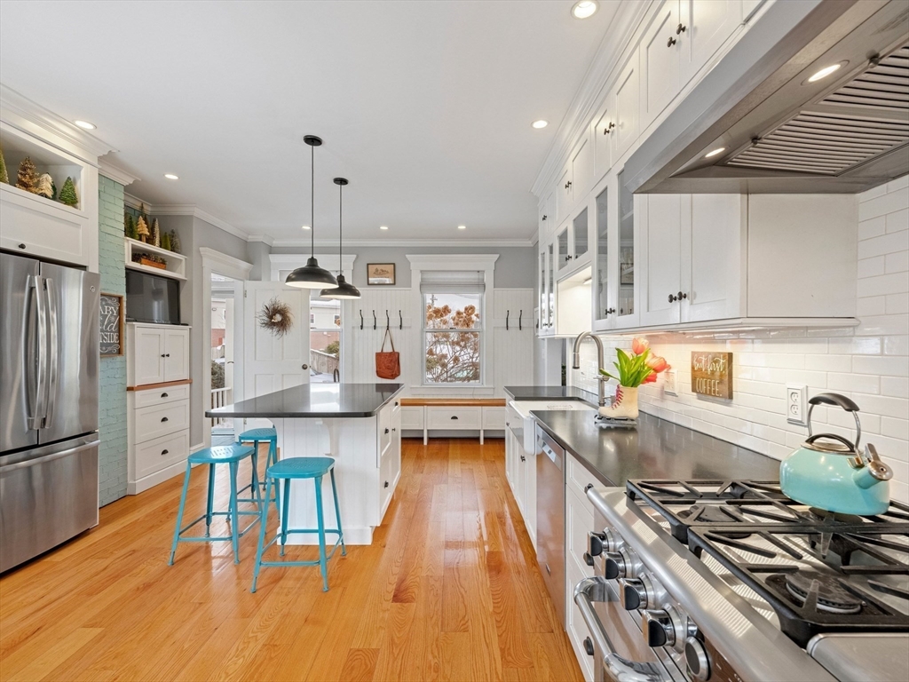 5 Holten Street Danvers, MA 01923 - Photo 7 of 42 a kitchen with stainless steel appliances a stove a sink dishwasher a refrigerator white cabinets and wooden floor