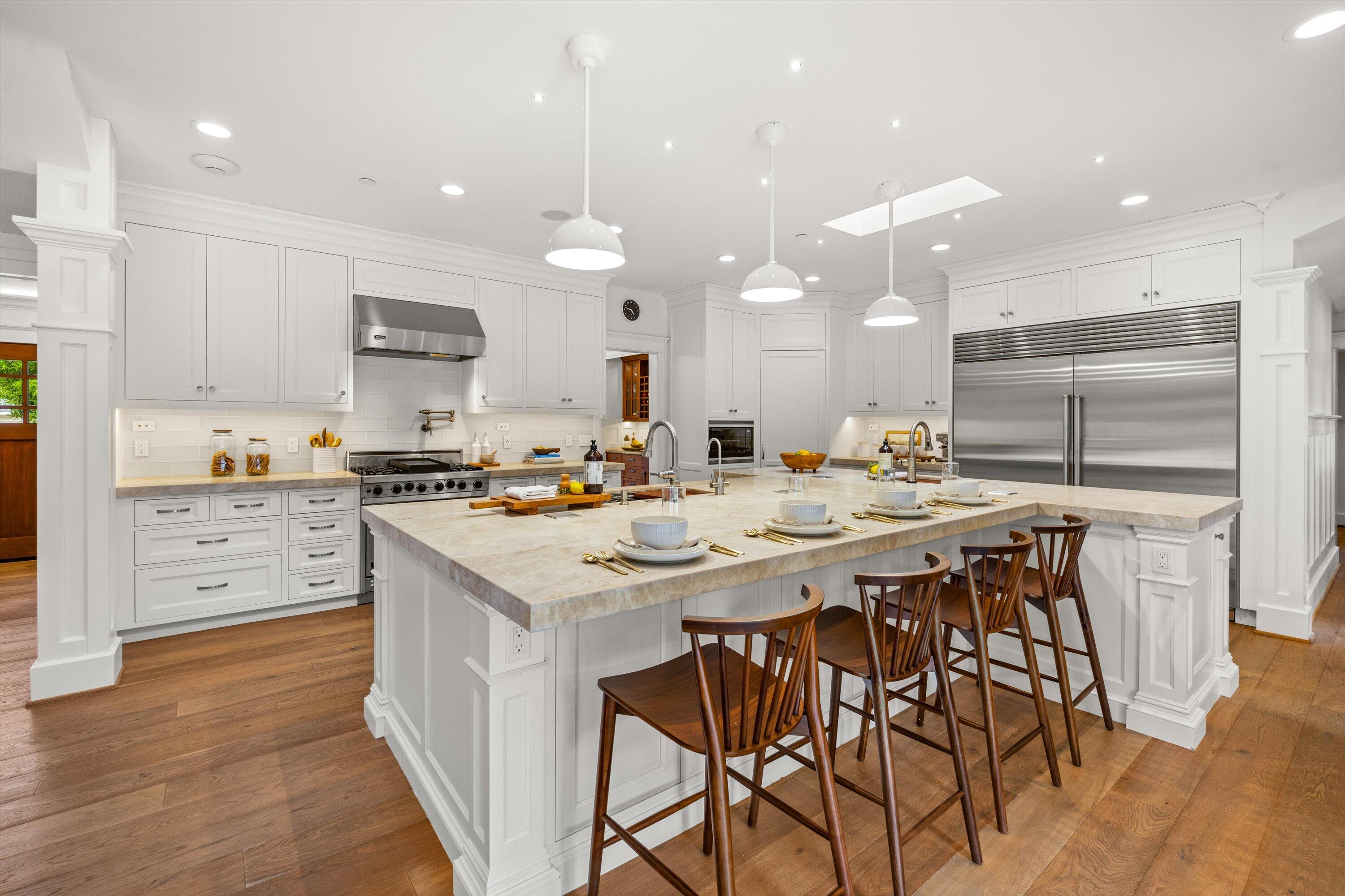 155 Santa Isabel Lane Montecito, CA 93108 - Photo 7 of 37 a kitchen with stainless steel appliances kitchen island granite countertop a table chairs sink and cabinets