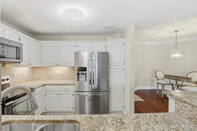 a view of a livingroom with furniture a chandelier and wooden floor