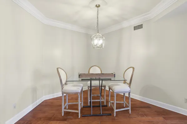 a dining room with furniture a chandelier and wooden floor