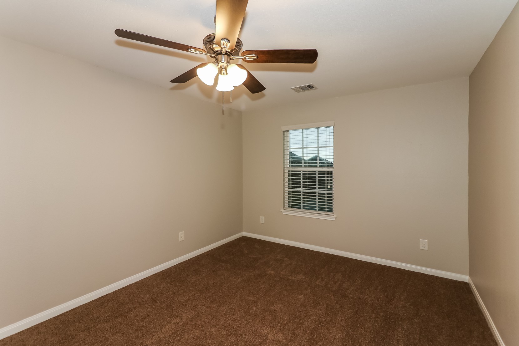 10311 Urban Oak Trail Houston, TX 77044 - Photo 9 of 15 an empty room with a window and a fan
