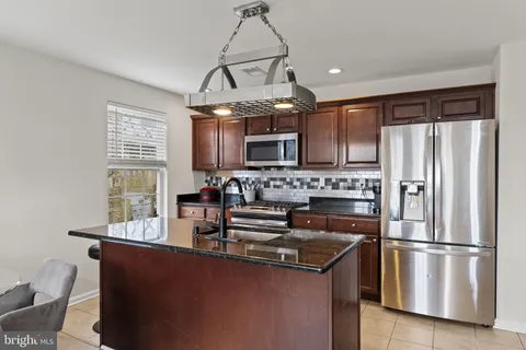 a kitchen with stainless steel appliances a refrigerator a stove a sink and a microwave