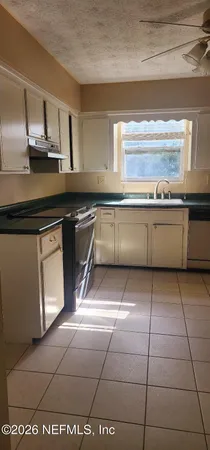 a kitchen with a sink a stove cabinets and counter space