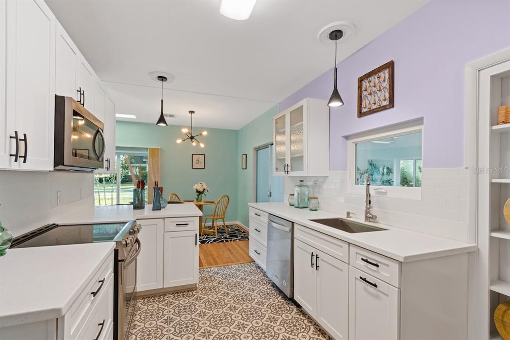 108 Northwest 2nd Street Williston, FL 32696 - Photo 15 of 45 a large white kitchen with a stove a sink a window and a dining table