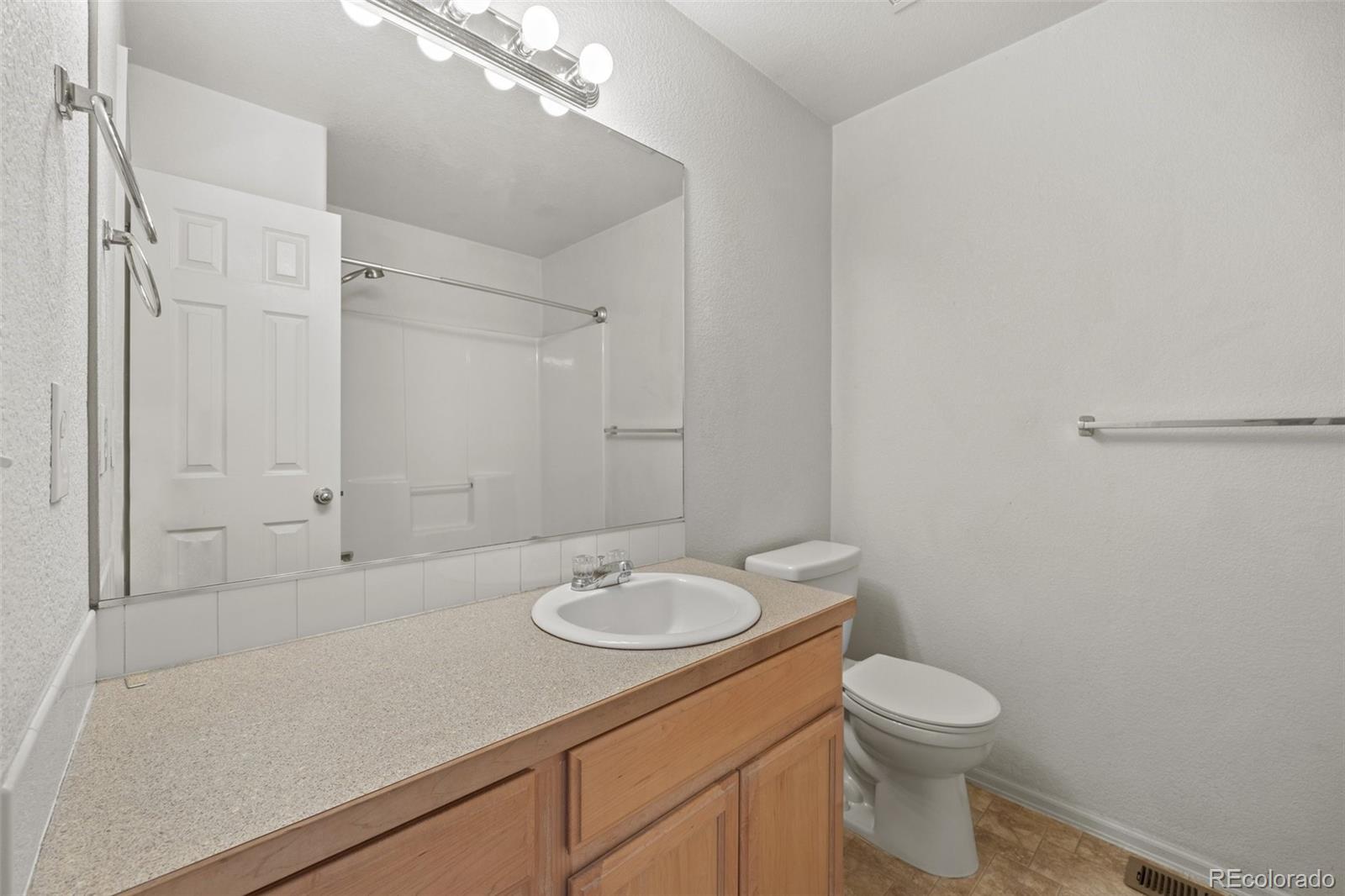 5328 Rustic Avenue Firestone, CO 80504 - Photo 13 of 22 a bathroom with a granite countertop sink toilet and a mirror
