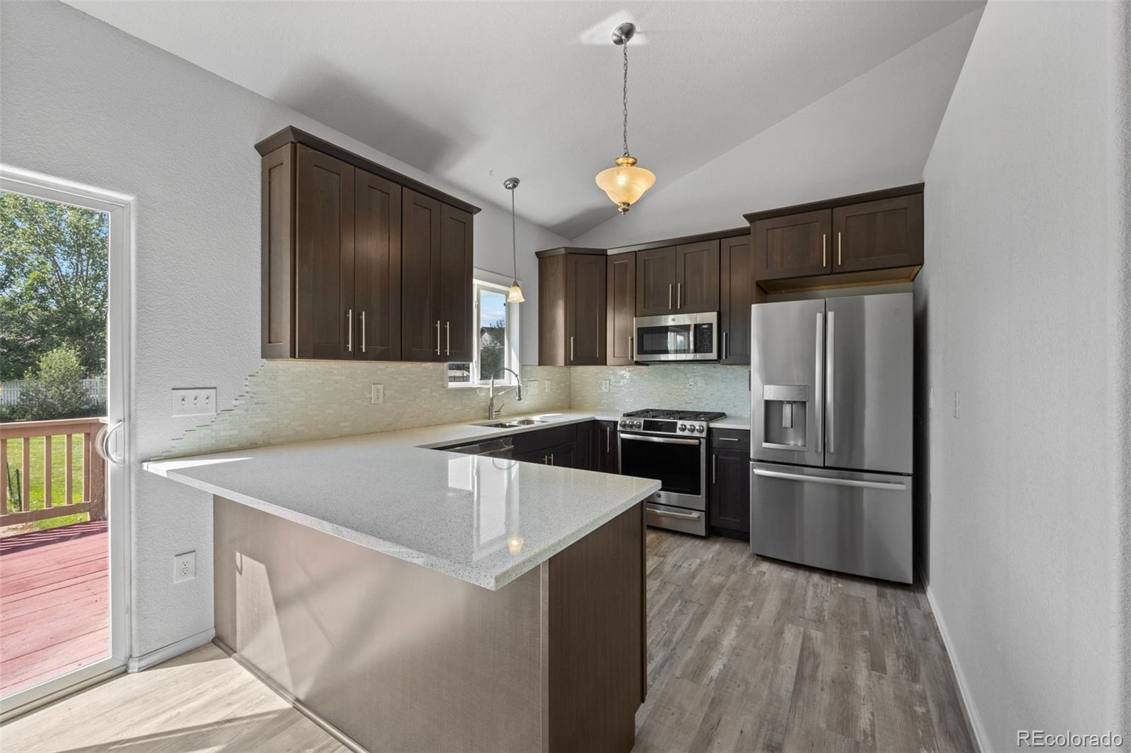 5328 Rustic Avenue Firestone, CO 80504 - Photo 3 of 22 a kitchen with wooden cabinets and stainless steel appliances