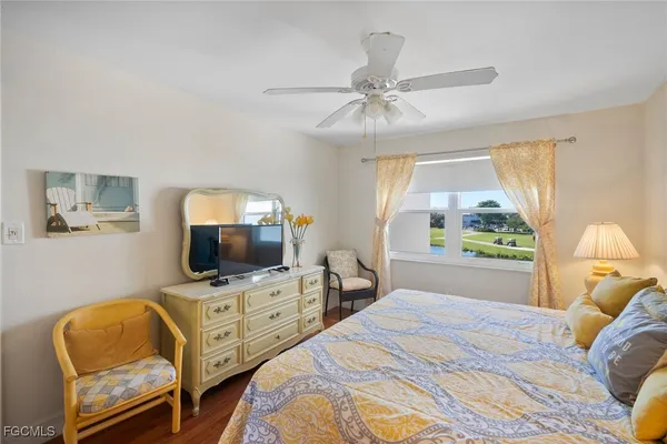 a bedroom with a bed tv and a window